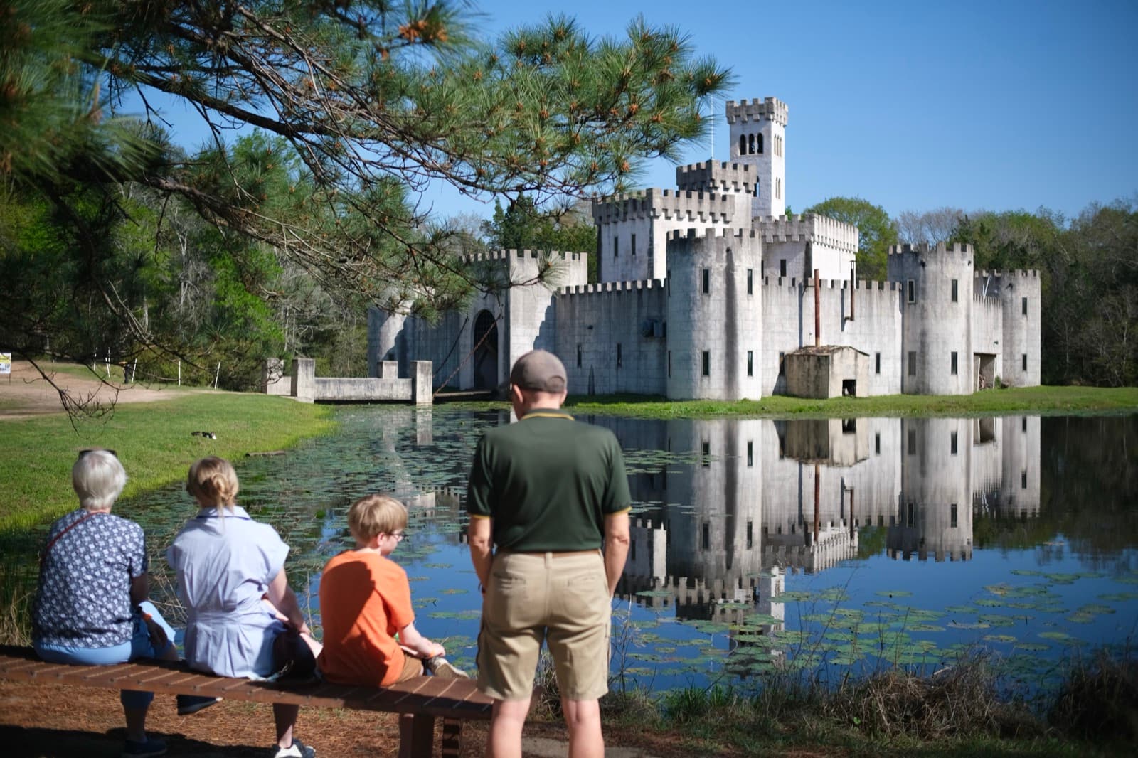 Family in front of a castle reflected in a pond near Houston